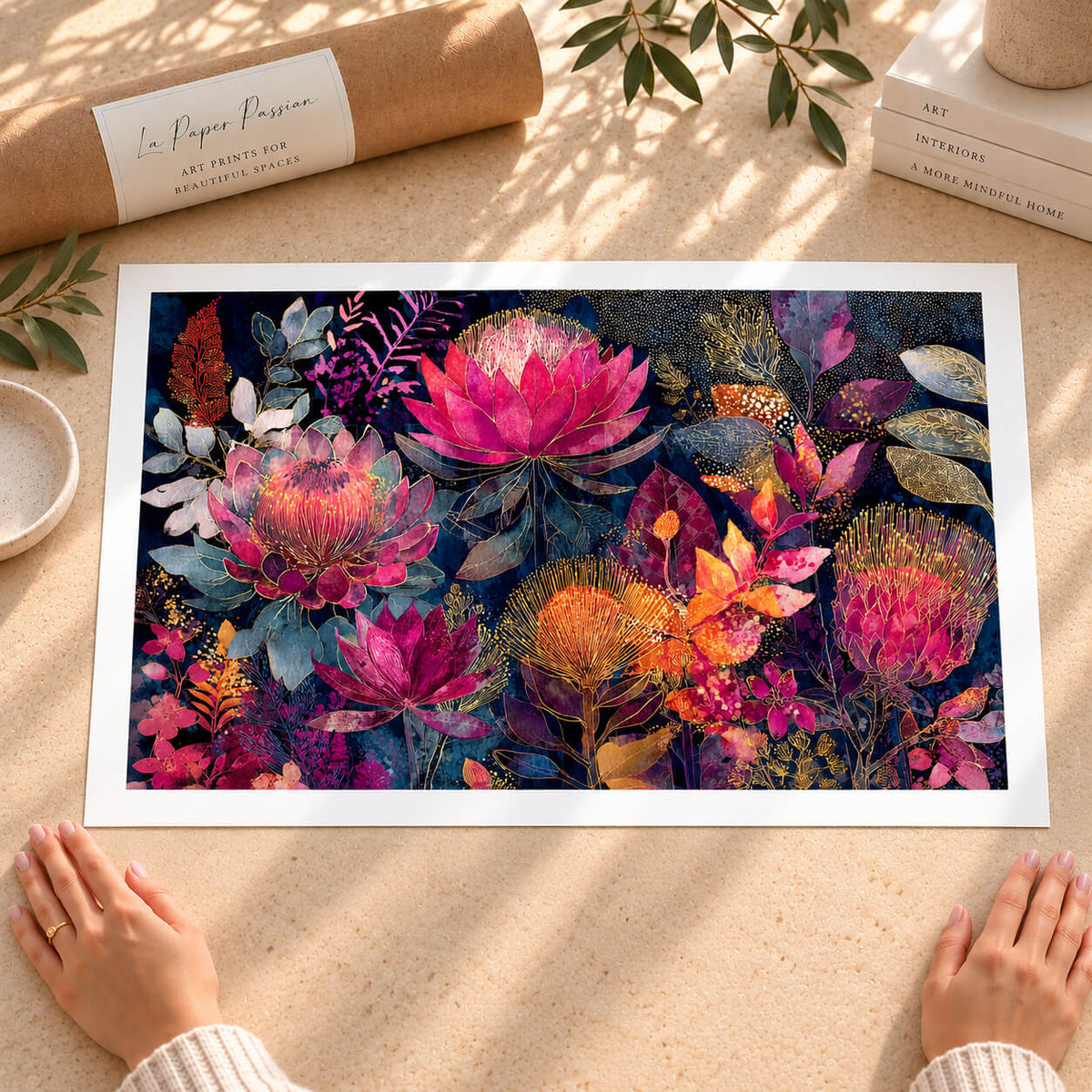 Large horizontal Australian floral wall art in a natural oak frame above a neutral sofa, featuring colourful proteas and banksia flowers.