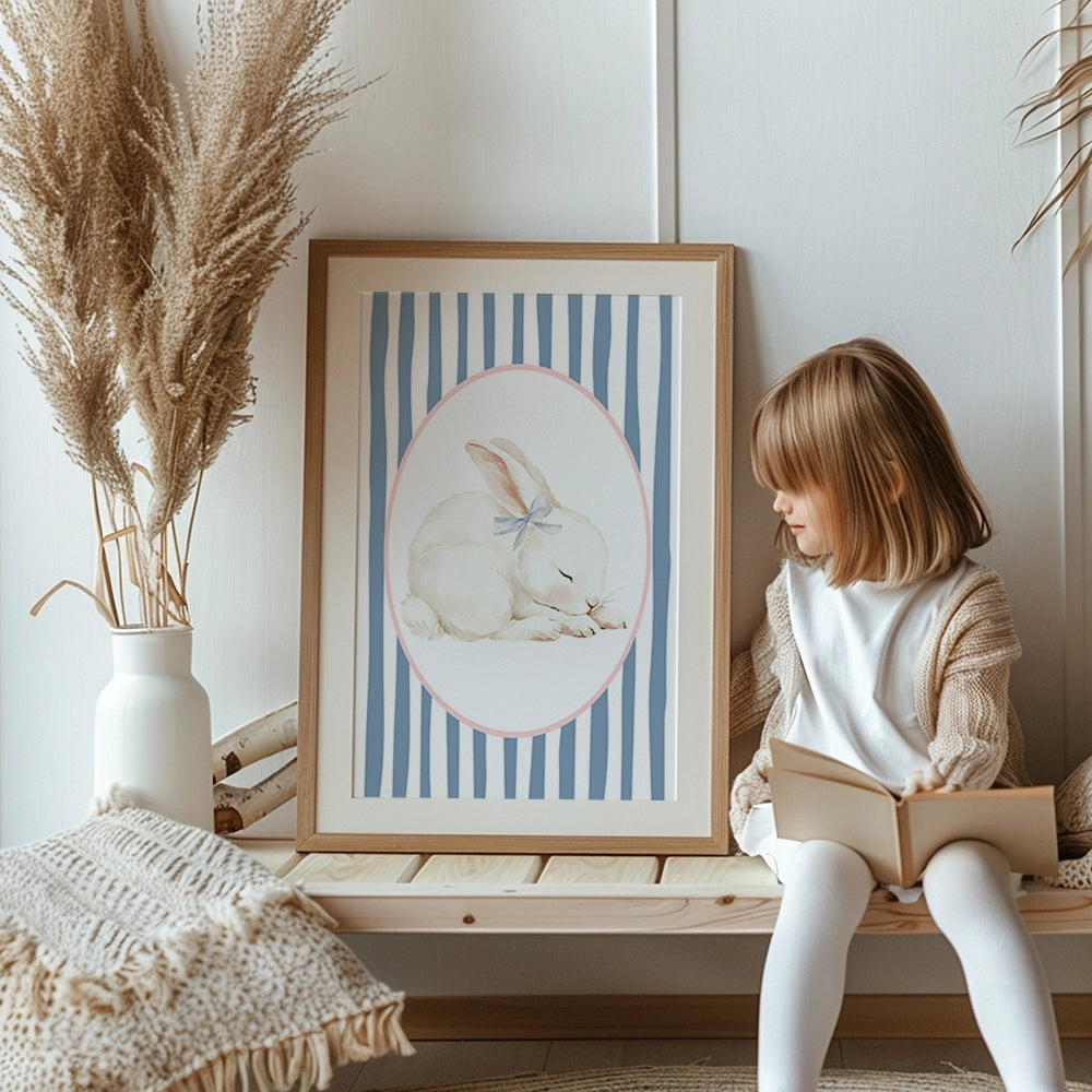 bunny with blue bow near its ear in an oval shape on blue and white stripe