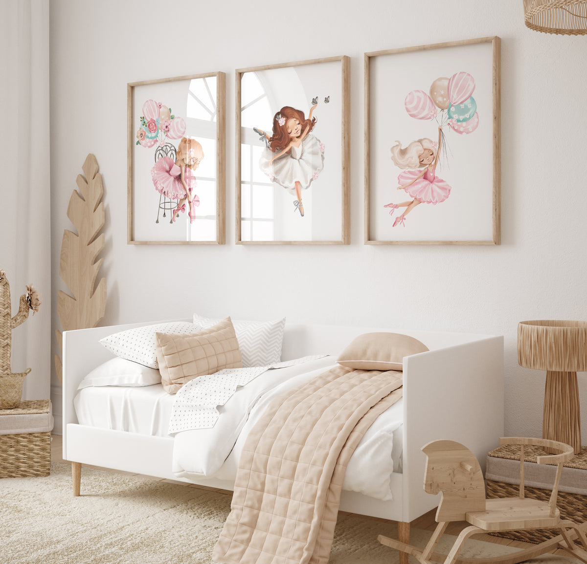 A set of three framed wall art prints featuring illustrations of ballerinas, mounted on a wall above a bed in a child&#39;s bedroom.