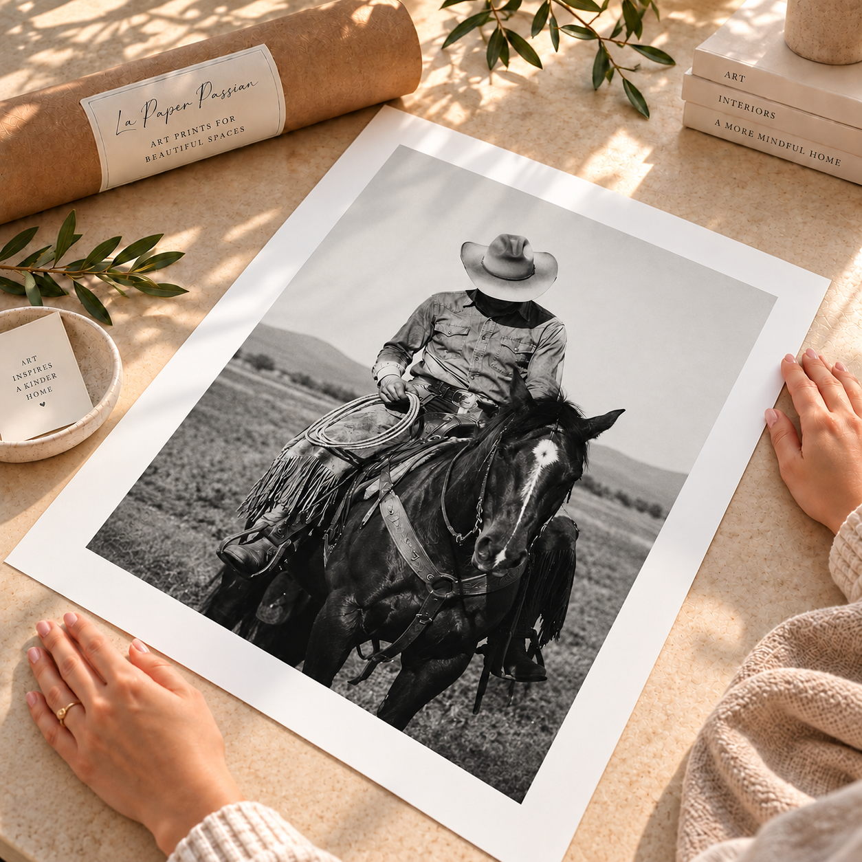 Black and white cowboy on horseback wall art featuring a traditional ranch cowboy wearing a western hat, leather chaps and holding a rope.
