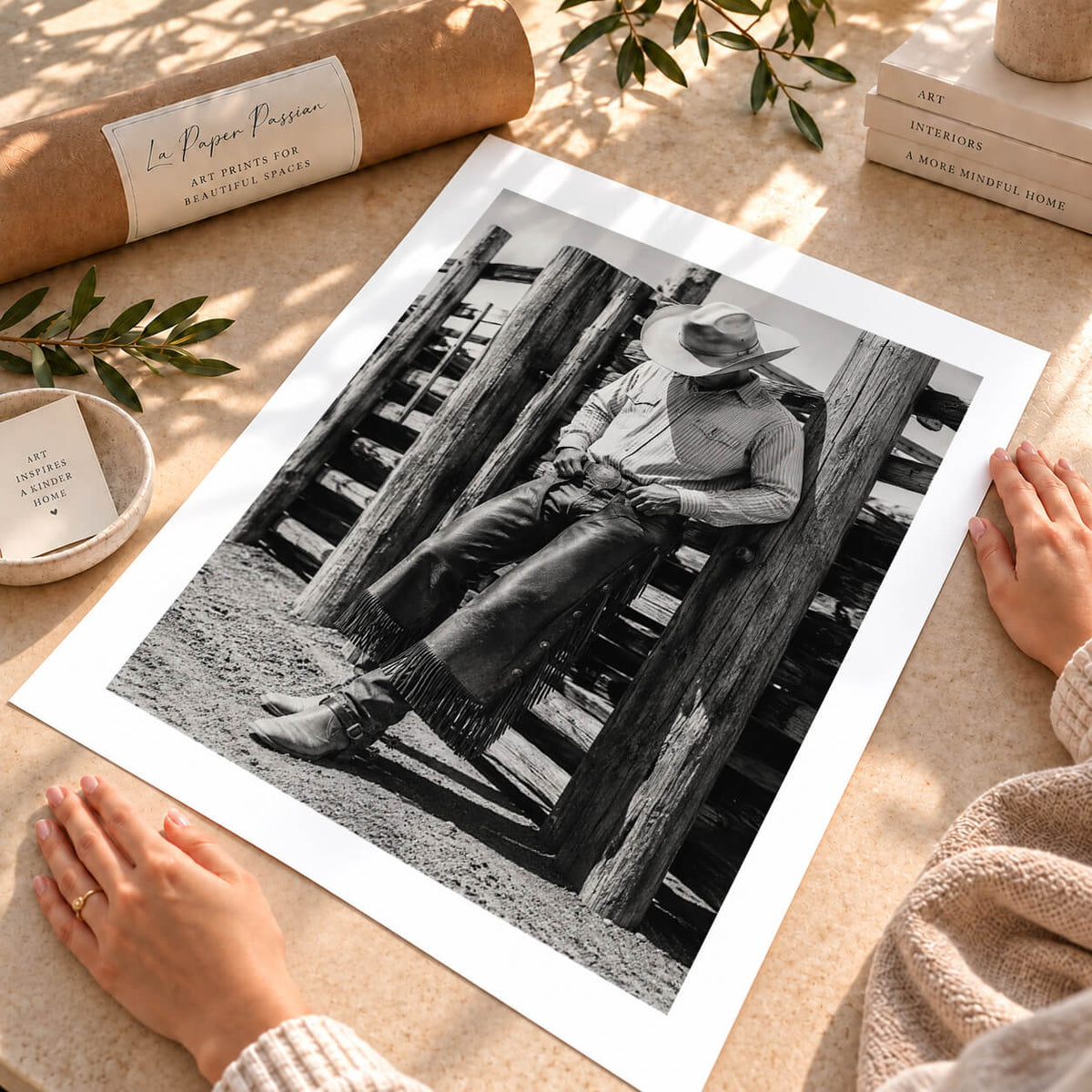 Black and white Western cowboy print featuring cowboy hat, leather chaps and timber ranch fence.